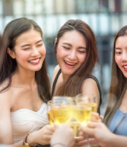 Happiness Asian Girl Friend Group celebrating and Cheering together with glass of wine at sunset time on rooftop of downtown hotel or nightclub,hens night,holiday, or yearly anniversary party concept